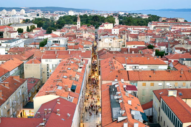 Aerial view of Zadar, Croatia with water in the background and many orange roof tops making up of the city.