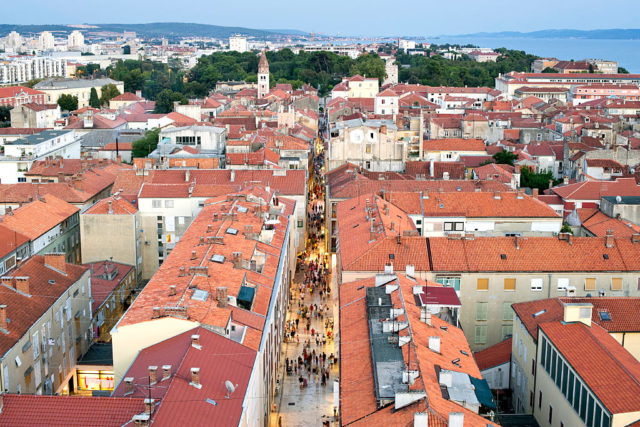Aerial view of Zadar, Croatia with water in the background and many orange roof tops making up of the city.