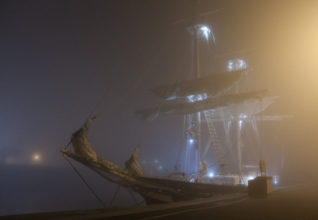 A docked ship with fog and spooky lighting