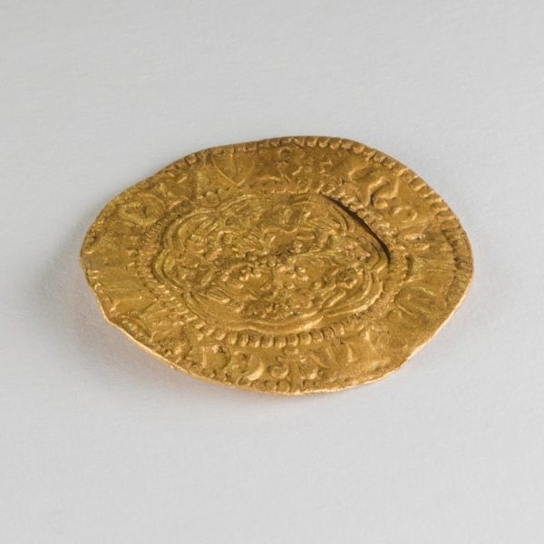 Medieval gold coin against a grey backdrop