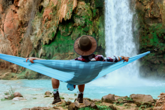 A man sits in a hammock at a Supai waterfall