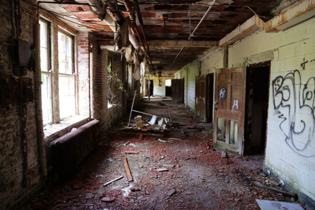 A destroyed hallway with graffiti on the walls