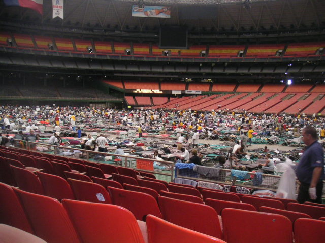 Evacuees laying on cots in the middle of the Houston Astrodome