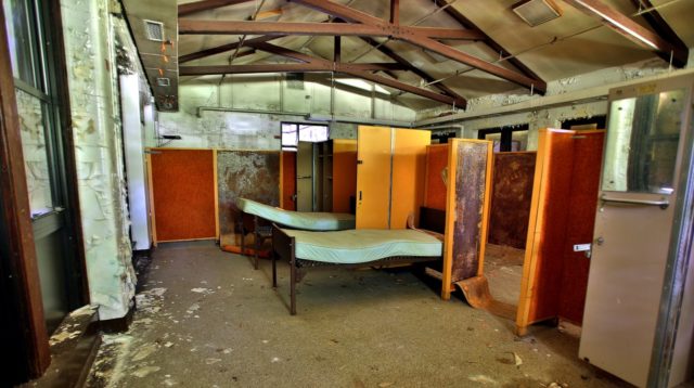 Mattresses sit in an abandoned and decaying room