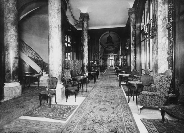 Interior of the Ritz Paris with large stone columns, tables, and chairs.