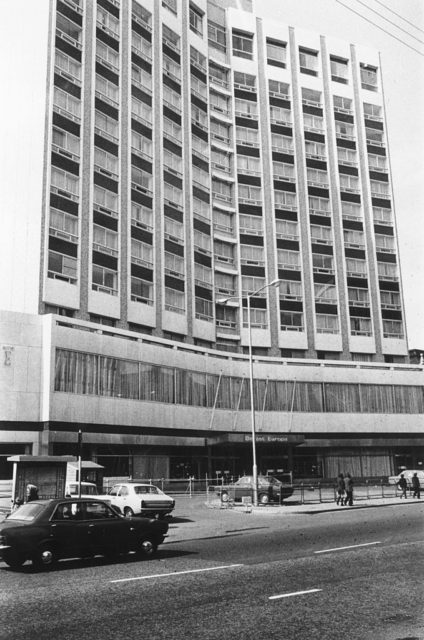 Exterior of the Europa Hotel with numerous cars parked out front.