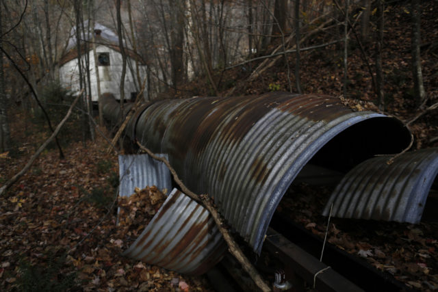 Rusty and damaged mine conveyor in the middle of a forest