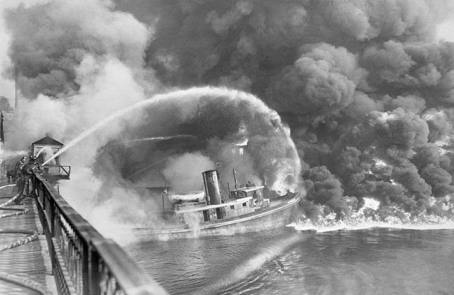 Fireman with water hoses try to put out the flames on the Cuyahoga River