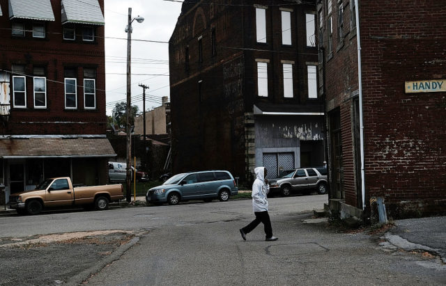 A person crosses the road in an empty part of town