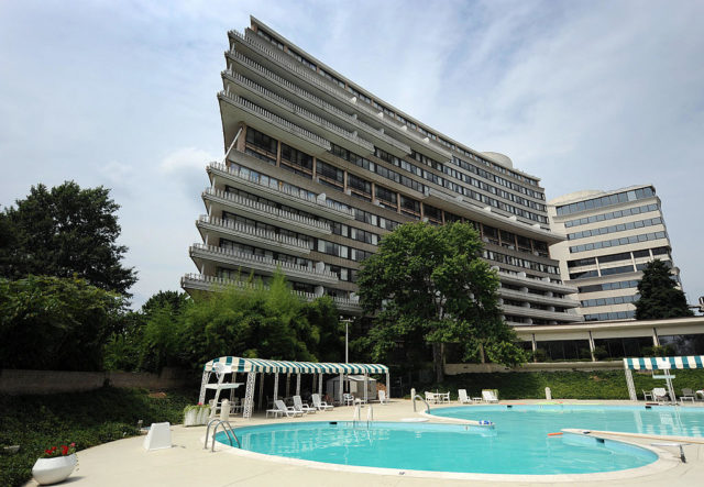 View of the Watergate Hotel with a pool in the foreground.