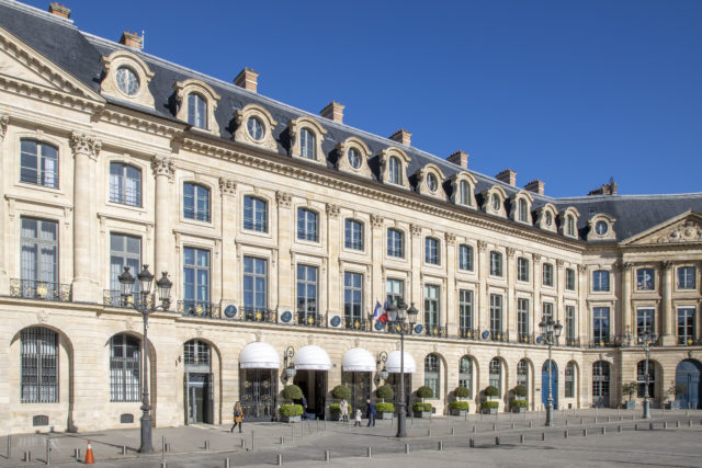 Exterior of the Ritz Paris with people walking in front of the entrance.