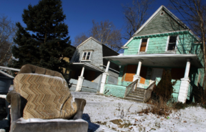 An abandoned chair sits in front of a home