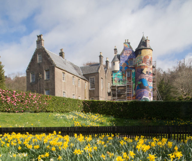 A view of the back part of Kelburn Castle contrasts with the brightly painted tower