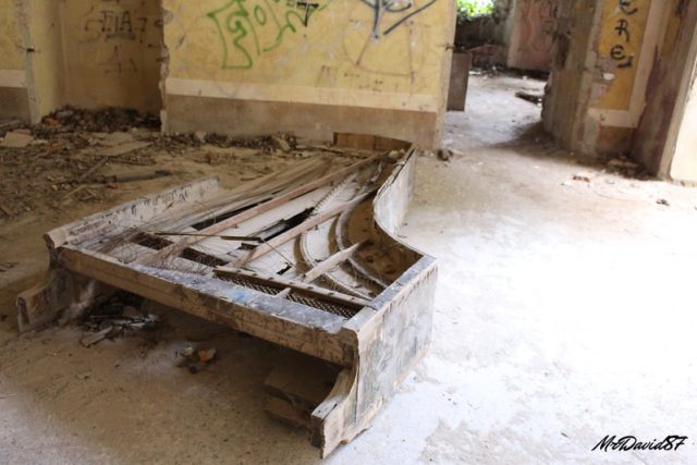 Abandoned piano missing the legs.