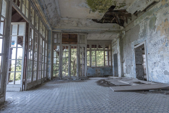 Open interior room of the villa with large windows and tile floors.