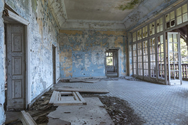 Open interior room of the villa with large windows and tile floors.