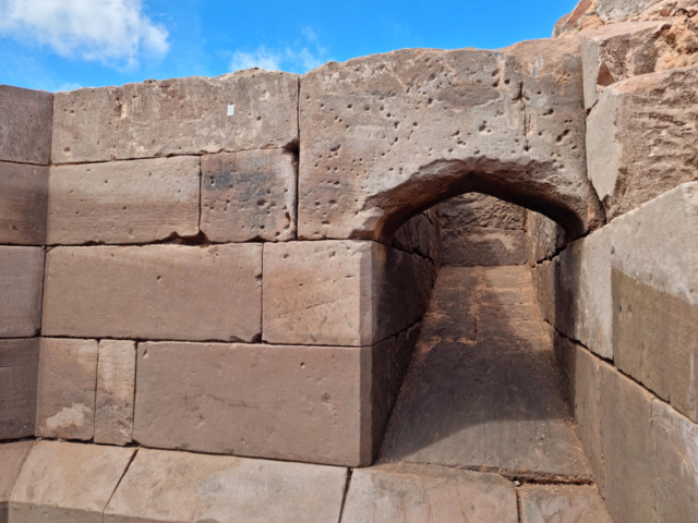 Musket ball impact marks on the outside of a wall with arched entrance.