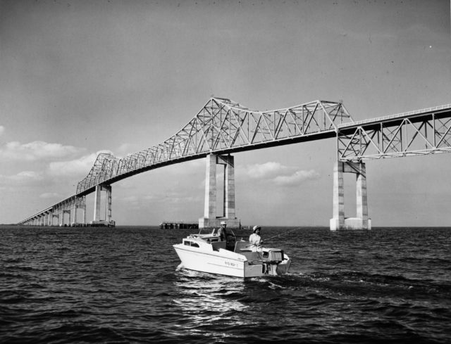 A bridge in water, a motorboat in the foreground