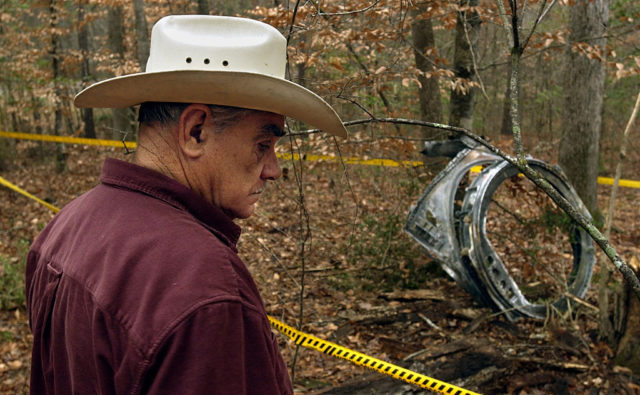 A man looks at a large piece of debris from the Columbia disaster