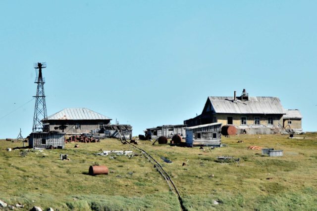 Abandoned buildings and an old radio tower on Kolyuchin Island