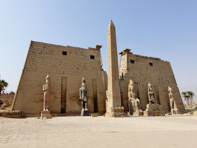 Luxor Temple with Egyptian statues and a tall column in front.
