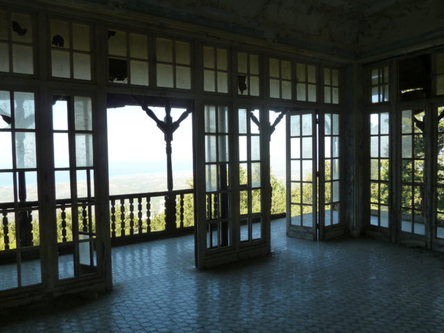 View looking out of the villa through floor to ceiling glass windows.