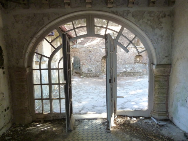 Arched glass door leading to a brick courtyard.