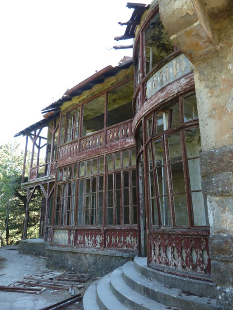 Faded red wood accented windows along the exterior of the Mussolini villa.