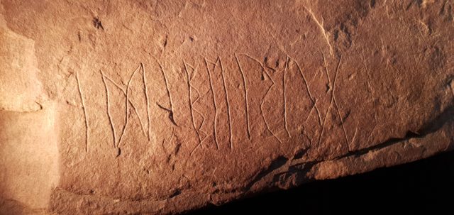 Slab of sandstone with rune markings on it.