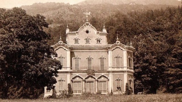 Sepia photograph of the Villa de Vecchi when it was still intact, surrounded by trees.