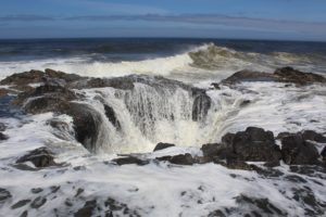 Water draining into a sinkhole next to the ocean.