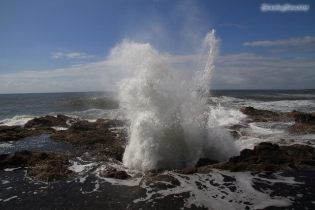 Water blasting from a rocky area by the ocean