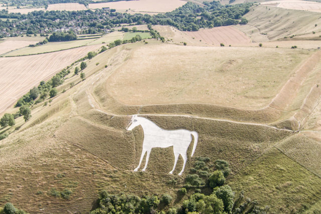 A white horse figure carved into the side of a hill.