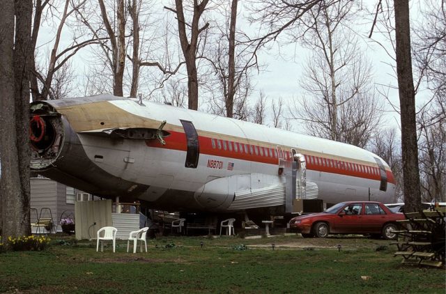 Wingless Boeing 727 sitting in the middle of a yard.