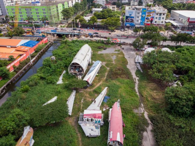 Birds eye view of abandoned planes on a lot.