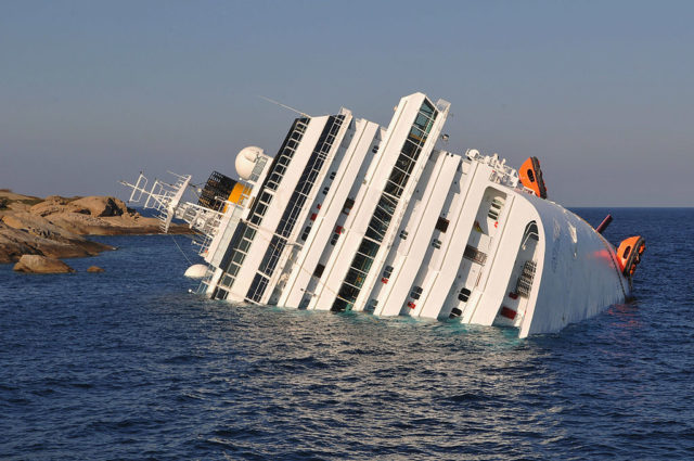 Costa Concordia lying on her side, half sunk in the water.