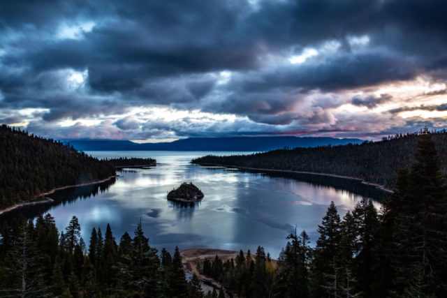 View of Lake Tahoe at sunset with clouds and sunset reflected in the water.