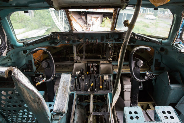 A damaged plane cockpit with wires exposed.