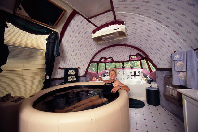 Jo Ann Ussery sitting in a hot tub inside her converted plane home.