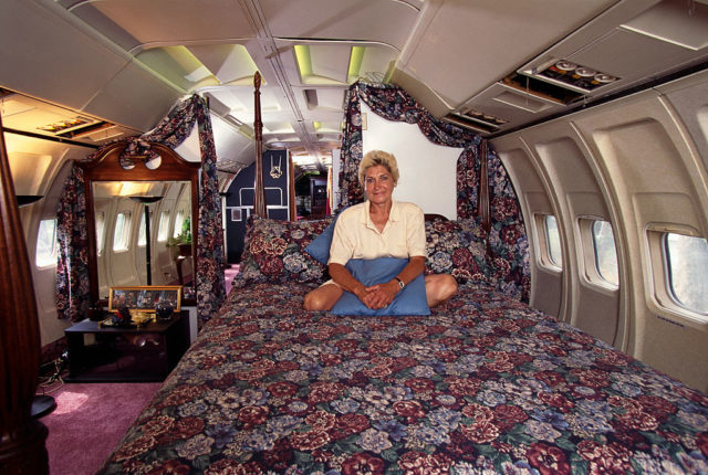 Jo Ann Ussery sitting on a floral bed inside her converted plane home.