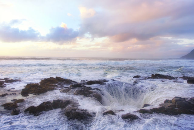 Water draining from ocean into a hole