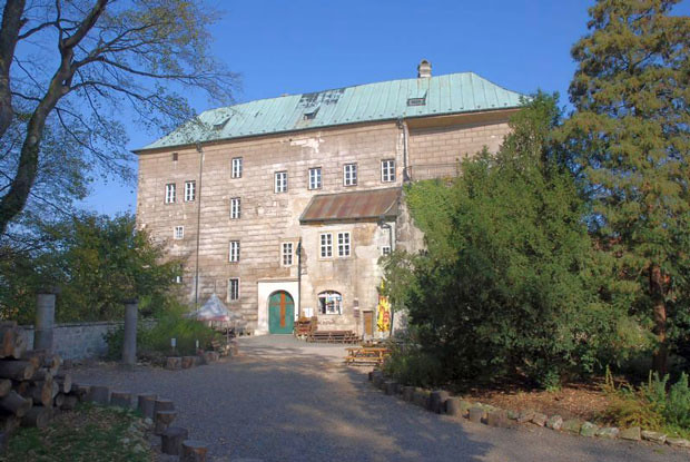 Exterior of Houska Castle surrounded by trees. 