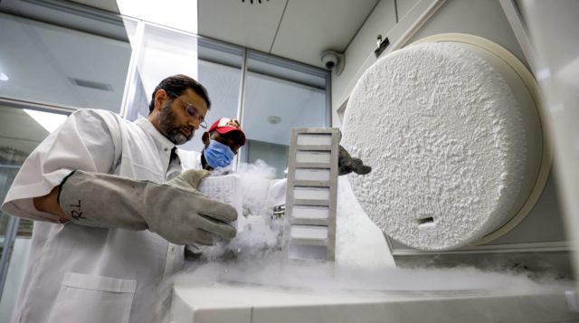 Nasir Ahmad Wani standing over a container filled with liquid nitrogen