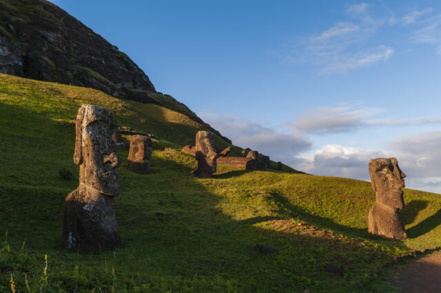 Moai statues positioned along the side of a hill