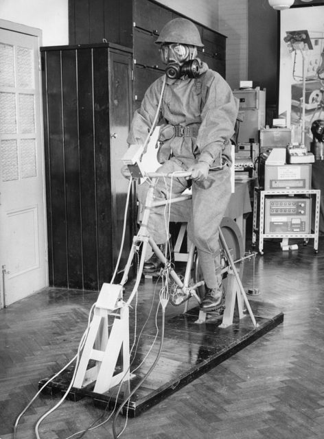 Soldier with a gas mask on a stationary bike.