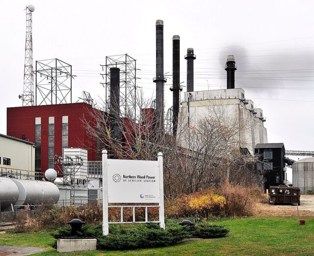 Red power plant with smoke stacks. 