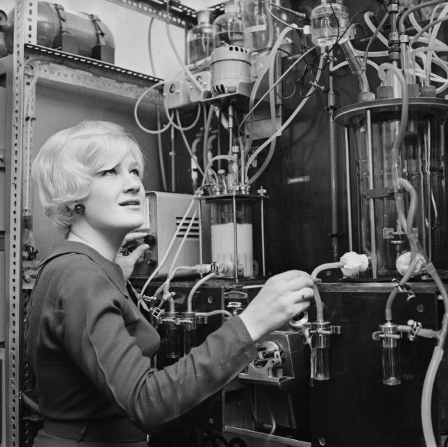 Woman fiddling with dials on a machine.