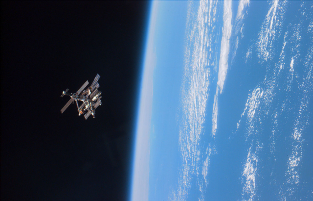 A satellite floating in space, Earth can be seen on the right of the photo.