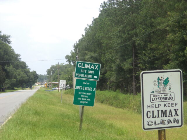City limit sign for Climax, Georgia and a anti-littering sign saying, "Help Keep Climax Clean"