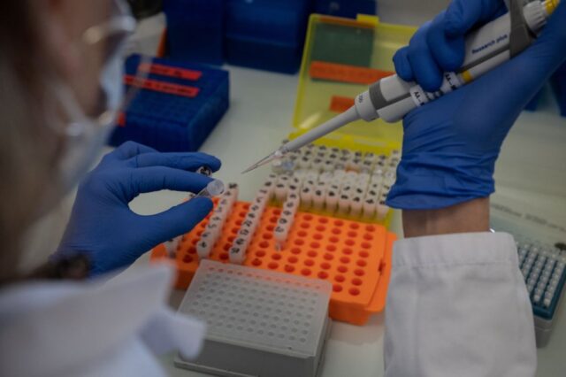 Scientist inserting liquid into a test tube